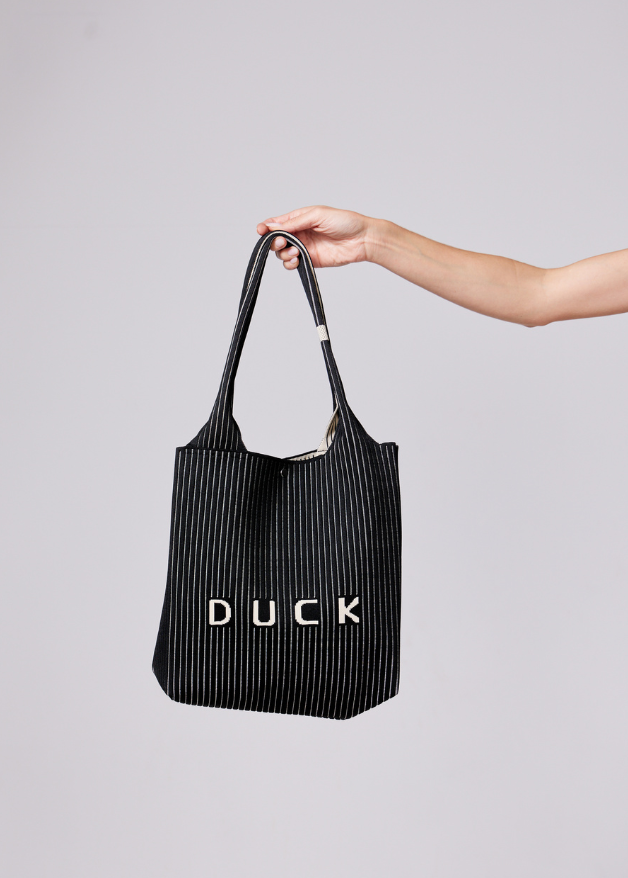 The Duck™ black woven tote bag with white pinstripes, sustainable fabric shopper with embroidered DUCK logo, reusable eco-friendly tote for everyday use