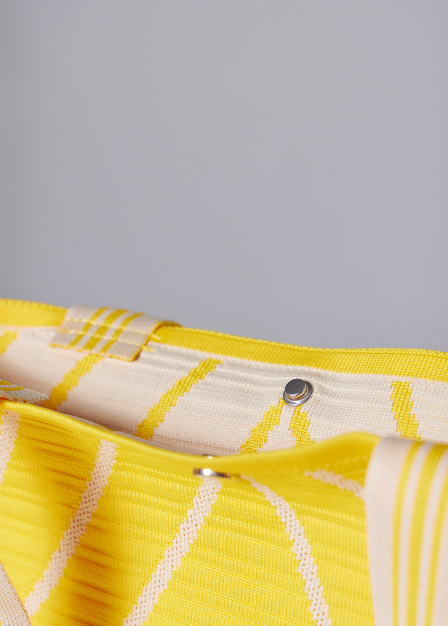Yellow woven handbag with white diagonal stripe design, lightweight eco-friendly fabric tote bag with sturdy handles for everyday use