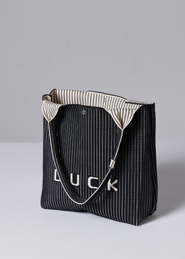 The Duck™ black woven tote bag with white pinstripes, sustainable fabric shopper with embroidered DUCK logo, reusable eco-friendly tote for everyday use