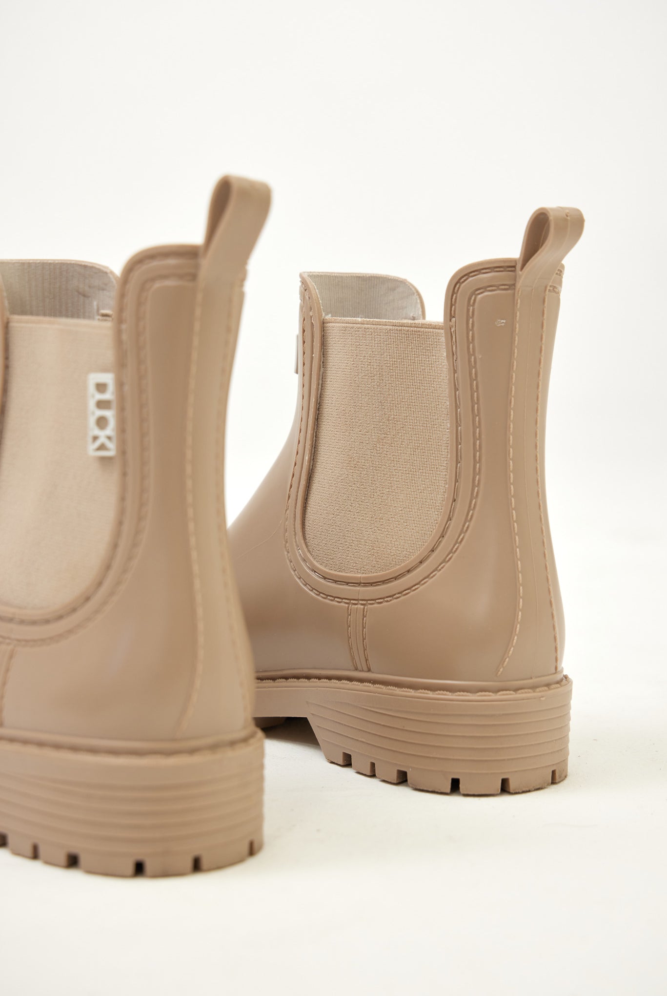 Beige Ankle-length gumboots with elastic side panels and durable sole, designed for everyday outdoor and wet-weather use