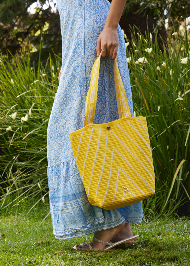 Yellow woven handbag with white diagonal stripe design, lightweight eco-friendly fabric tote bag with sturdy handles for everyday use