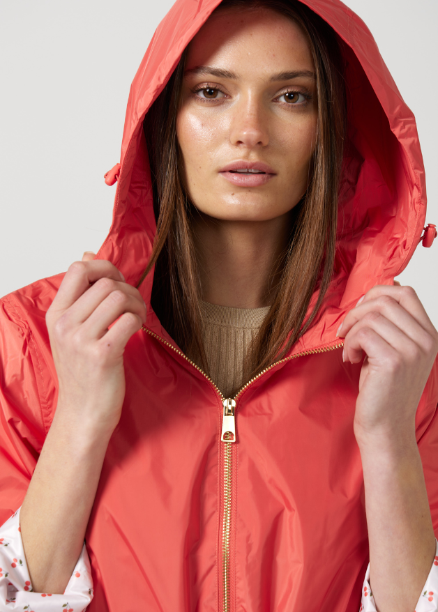 The Coral Spritz coral red hooded raincoat, modern lightweight waterproof raincoat perfect for Australia’s changing weather and rain