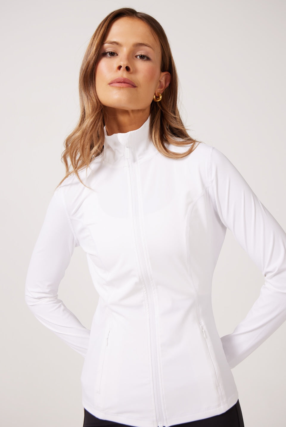 White Lightweight performance jacket with a smooth, sculpting fit, full zip front, high collar, and stretch fabric designed for everyday movement and layering.