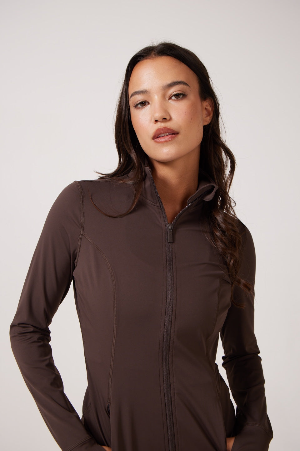 Brown Lightweight performance jacket with a smooth, sculpting fit, full zip front, high collar, and stretch fabric designed for everyday movement and layering.