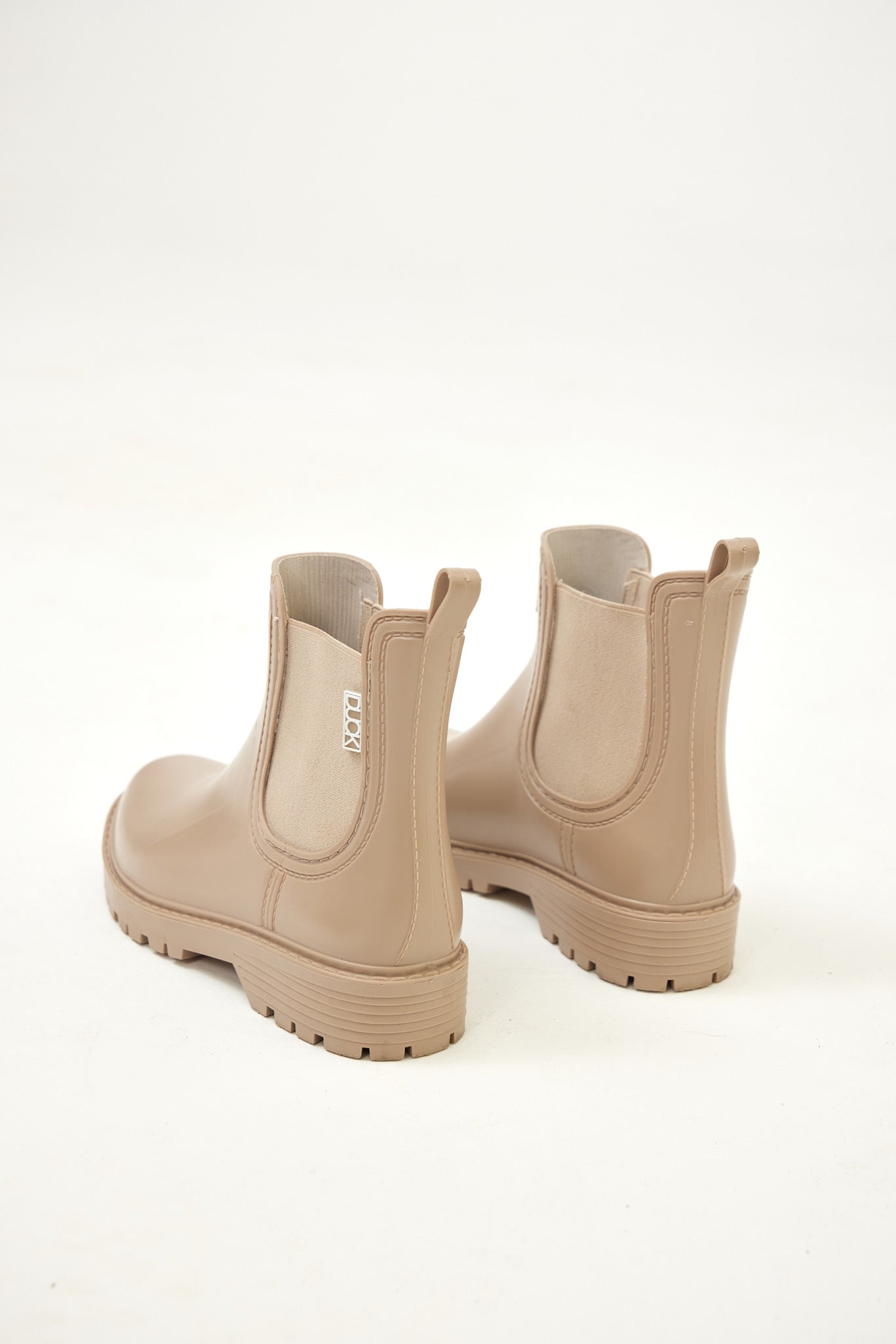 Beige Ankle-length gumboots with elastic side panels and durable sole, designed for everyday outdoor and wet-weather use