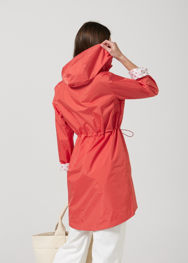 The Coral Spritz coral red hooded raincoat, modern lightweight waterproof raincoat perfect for Australia’s changing weather and rain
