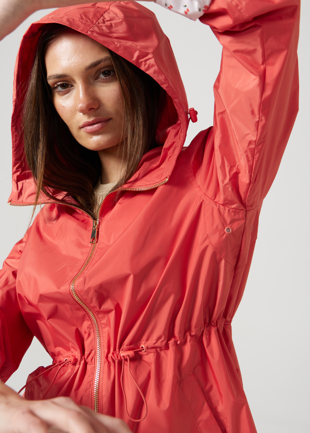 The Coral Spritz coral red hooded raincoat, modern lightweight waterproof raincoat perfect for Australia’s changing weather and rain