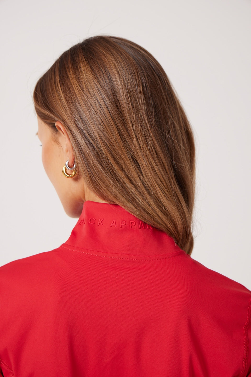 Red Lightweight performance jacket with a smooth, sculpting fit, full zip front, high collar, and stretch fabric designed for everyday movement and layering.