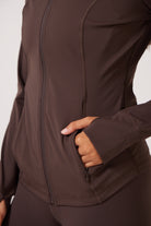 Brown Lightweight performance jacket with a smooth, sculpting fit, full zip front, high collar, and stretch fabric designed for everyday movement and layering.
