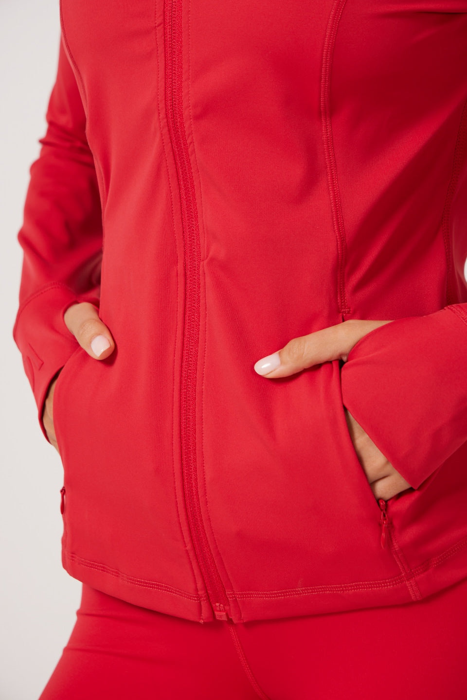 Red Lightweight performance jacket with a smooth, sculpting fit, full zip front, high collar, and stretch fabric designed for everyday movement and layering.